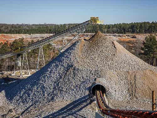 Surge Tunnel Reclaim Conveyor operating beneath large rock pile at South Carolina quarry site
